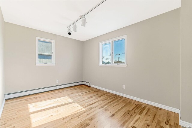 spare room featuring plenty of natural light, light hardwood / wood-style flooring, and a baseboard radiator