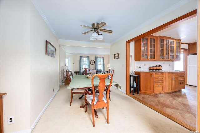 dining space with ceiling fan, crown molding, and light tile patterned flooring