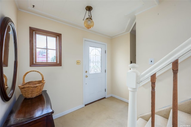 carpeted entrance foyer featuring crown molding