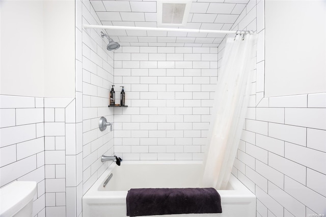 bathroom featuring toilet and shower / bathtub combination with curtain