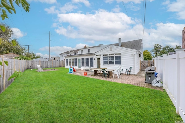 back of house with a lawn and a patio area