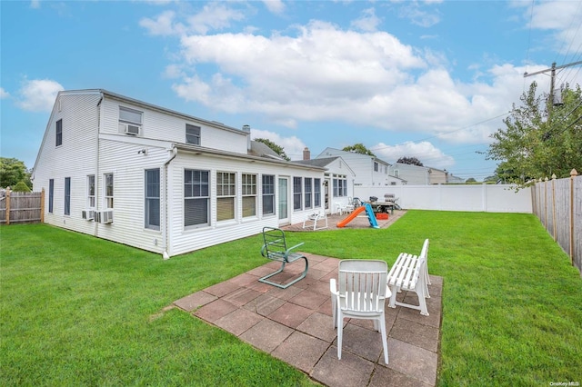 back of property with a lawn, cooling unit, and a patio area