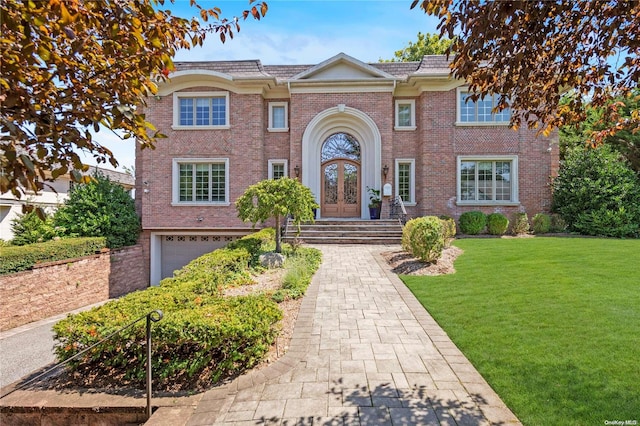 view of front of home with french doors, a garage, and a front lawn