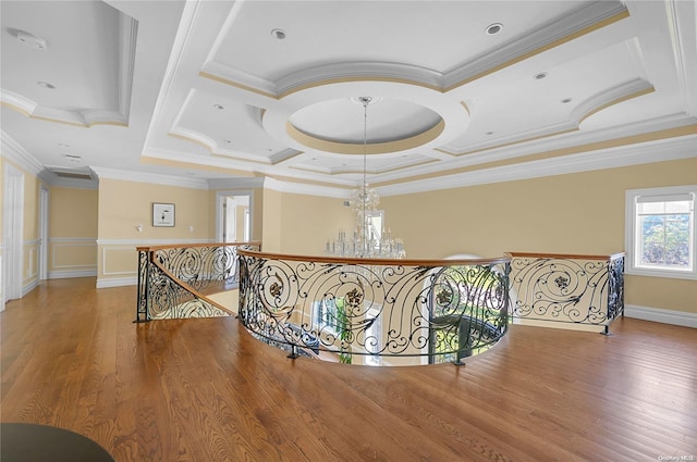 hallway with a notable chandelier, hardwood / wood-style floors, coffered ceiling, and ornamental molding