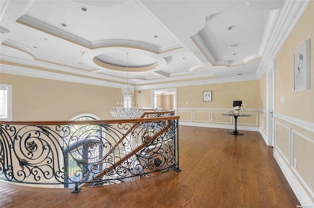 hallway featuring plenty of natural light, hardwood / wood-style floors, coffered ceiling, and ornamental molding