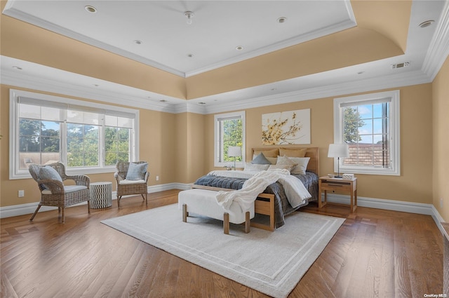 bedroom featuring wood-type flooring, a tray ceiling, and crown molding