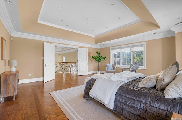 bedroom with dark hardwood / wood-style floors, a raised ceiling, and ornamental molding