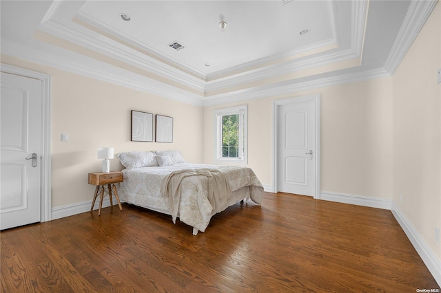 bedroom featuring dark hardwood / wood-style flooring, a tray ceiling, and ornamental molding