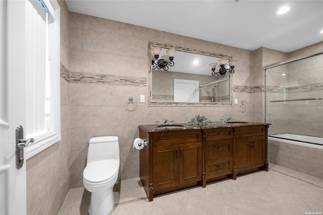 full bathroom with vanity, toilet, and tile walls