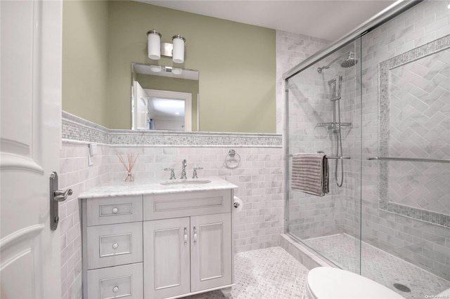 bathroom featuring vanity, an enclosed shower, and tile walls