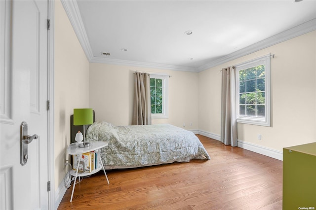 bedroom with hardwood / wood-style flooring and ornamental molding