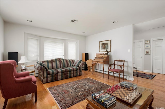 living room with light hardwood / wood-style flooring and a baseboard radiator