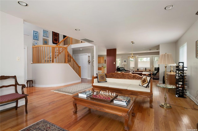 living room featuring a chandelier and wood-type flooring