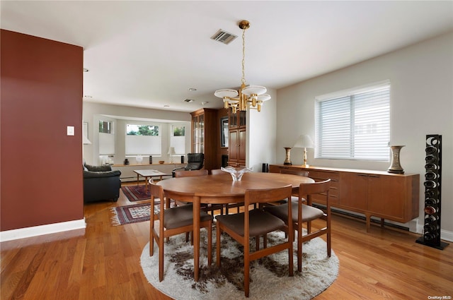 dining space featuring a chandelier and light hardwood / wood-style flooring