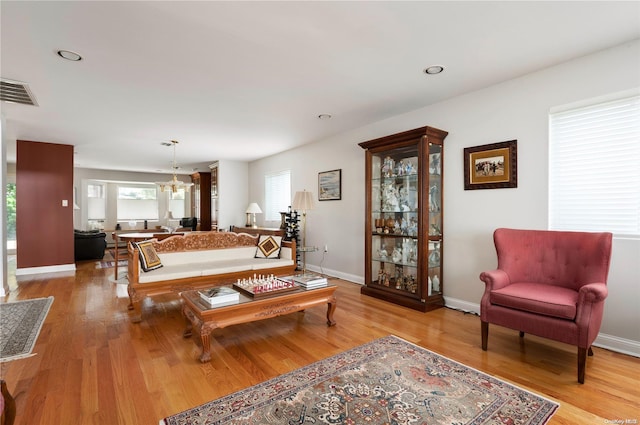 living room featuring a chandelier and light hardwood / wood-style flooring