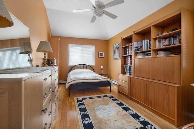 bedroom with light wood-type flooring, ceiling fan, and a baseboard heating unit