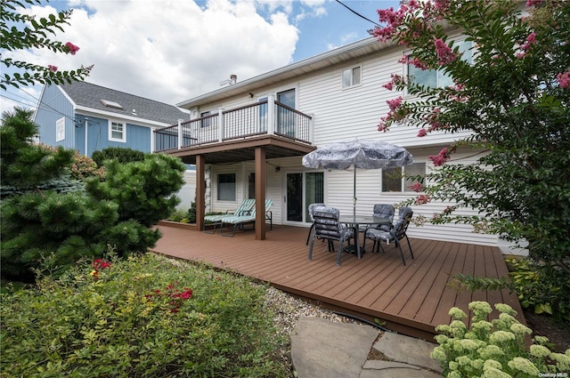 back of property with a balcony and a deck