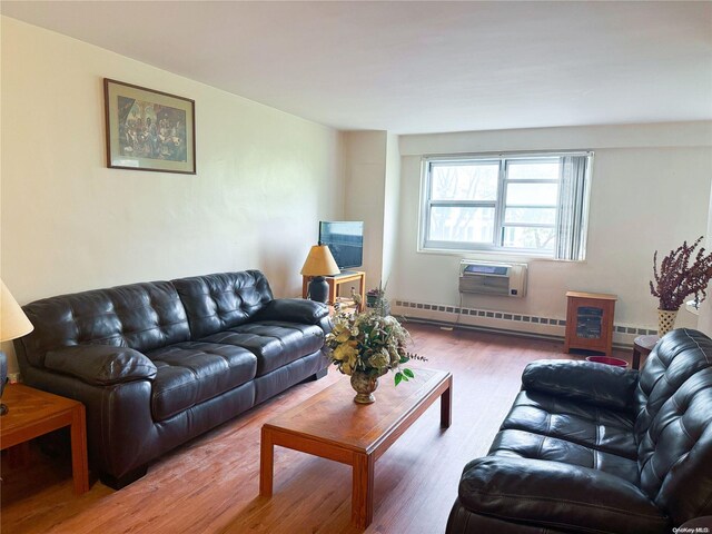 living room featuring wood-type flooring, a wall mounted AC, and a baseboard heating unit