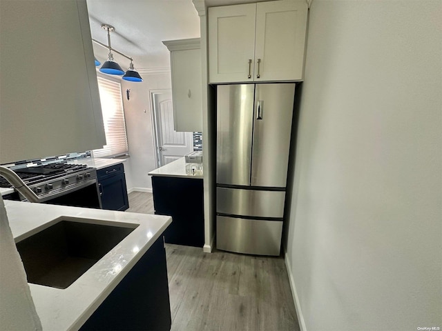 61-20 Grand Central Pkwy Unit B401, Forest Hills, NY 11375 - kitchen featuring appliances with stainless steel finishes, ornamental molding, decorative light fixtures, light hardwood / wood-style floors, and white cabinetry