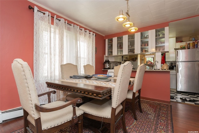 dining room with dark hardwood / wood-style flooring, a baseboard radiator, and ornamental molding