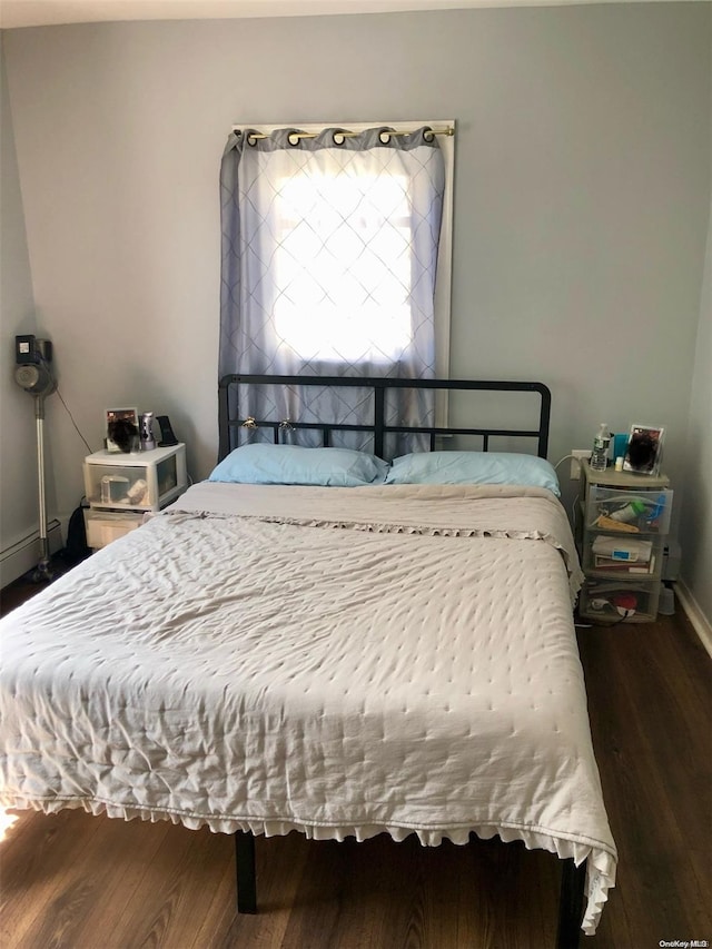 bedroom with dark hardwood / wood-style floors