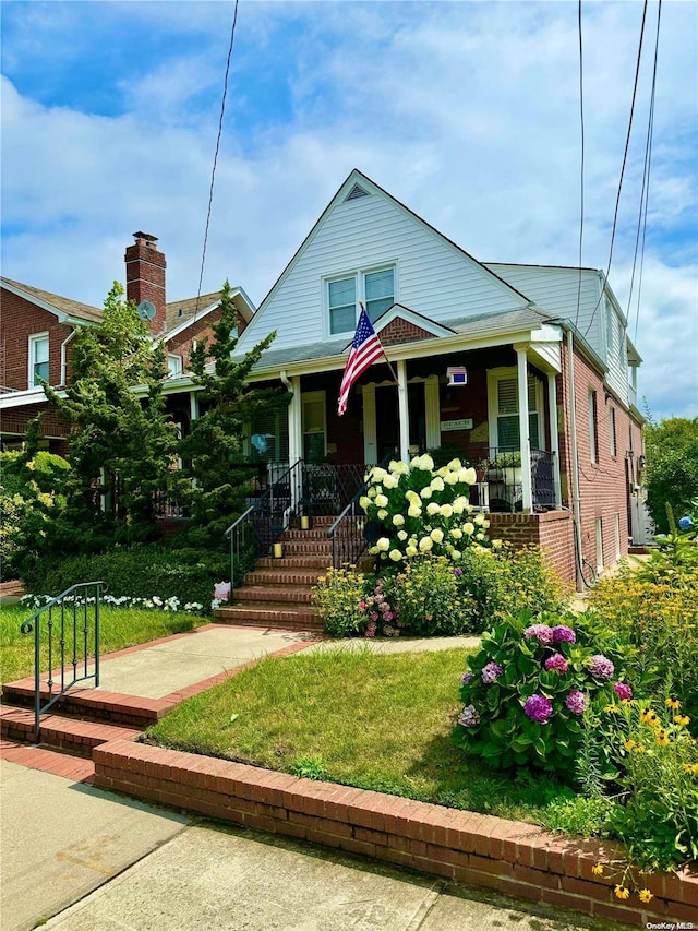 view of front of house featuring covered porch and a front lawn