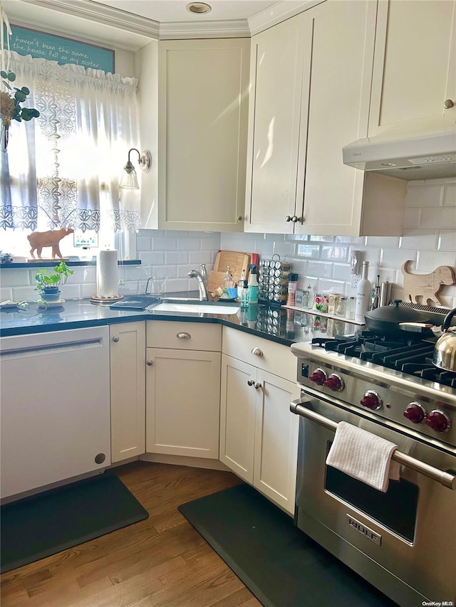 kitchen with decorative backsplash, designer range, sink, white cabinets, and dark hardwood / wood-style floors