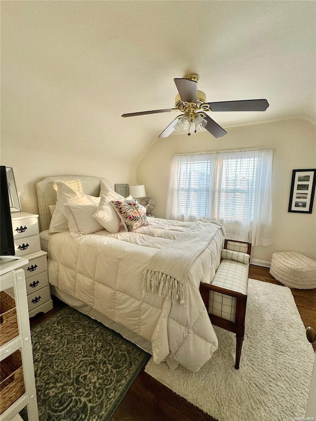 bedroom featuring ceiling fan, dark hardwood / wood-style flooring, and vaulted ceiling