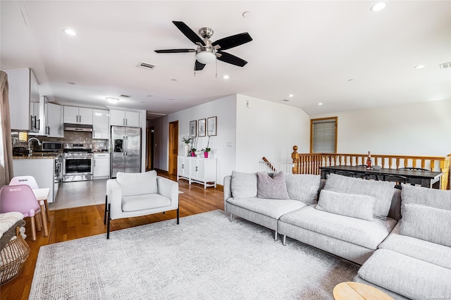 living room featuring hardwood / wood-style floors and ceiling fan