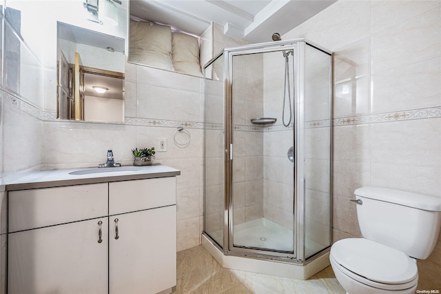 bathroom featuring an enclosed shower, vanity, toilet, and tile walls