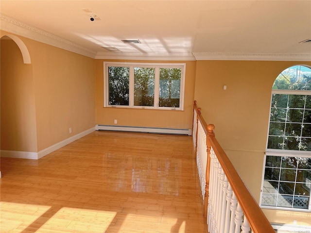 unfurnished room featuring crown molding, baseboard heating, and light hardwood / wood-style flooring