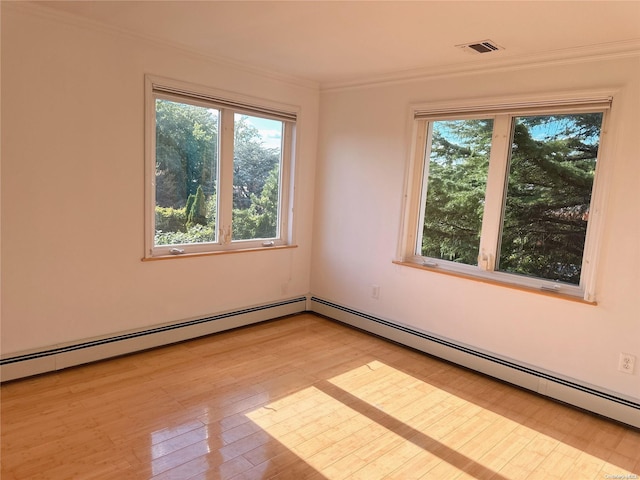 spare room with crown molding, plenty of natural light, and light wood-type flooring