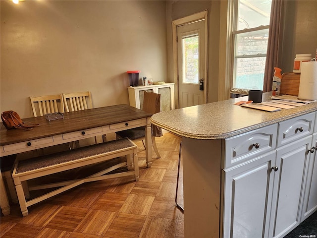 kitchen featuring white cabinetry and light parquet floors