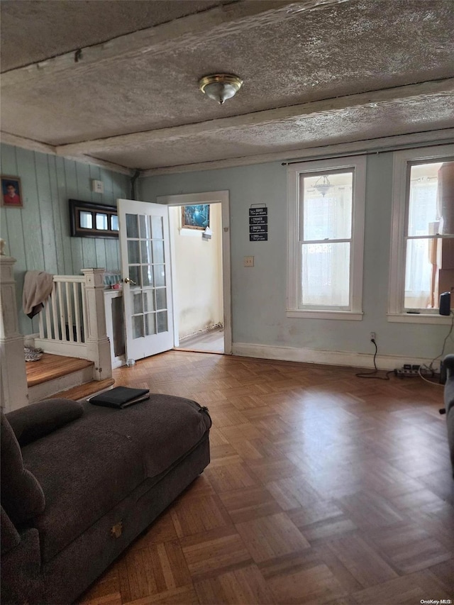 interior space with french doors, a textured ceiling, and parquet flooring