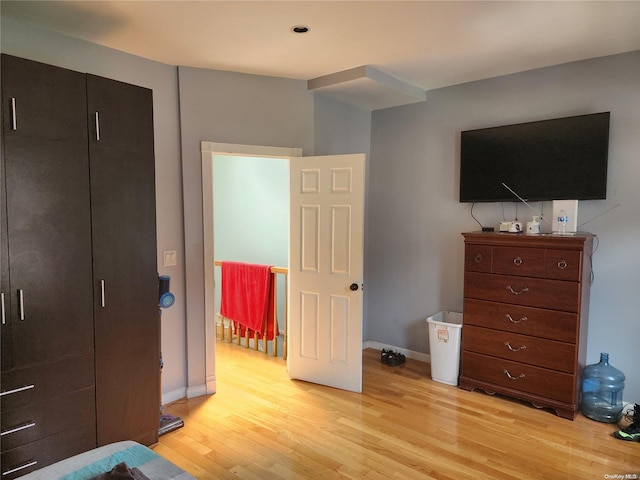 bedroom with light hardwood / wood-style flooring and a closet