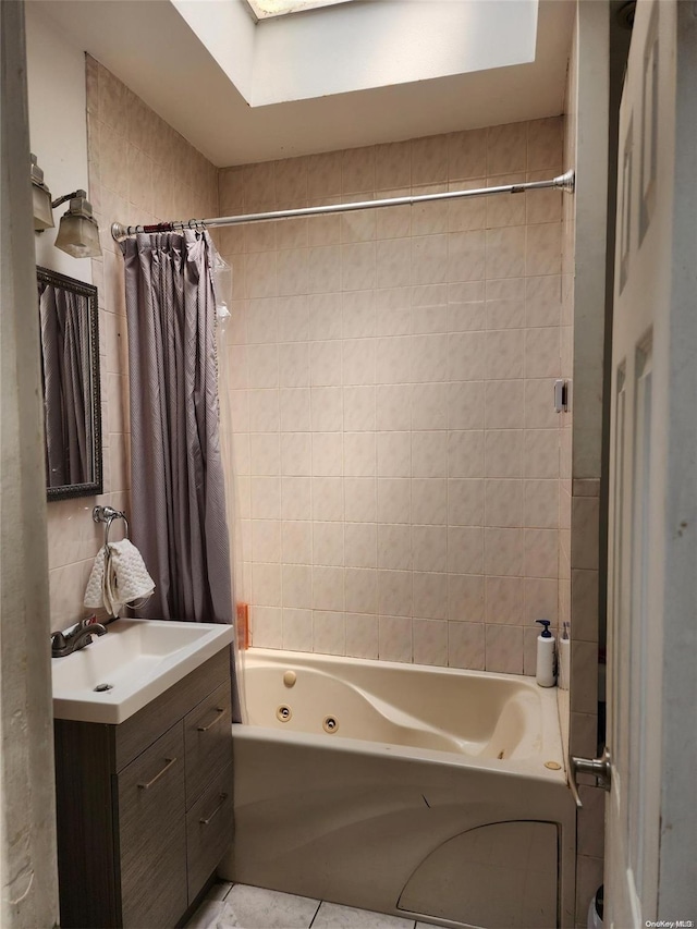 bathroom featuring tile patterned flooring, vanity, shower / bathtub combination with curtain, and tile walls