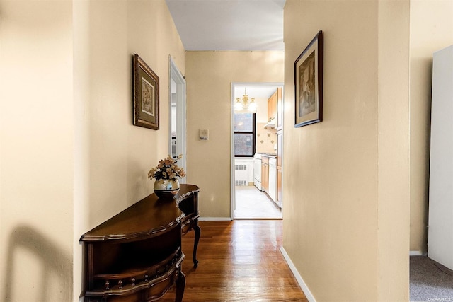 hall featuring hardwood / wood-style floors and an inviting chandelier