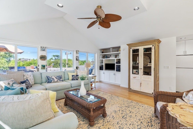 living room with light hardwood / wood-style floors, high vaulted ceiling, plenty of natural light, and ceiling fan