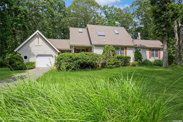 view of front of property with an attached garage, a front lawn, and roof with shingles