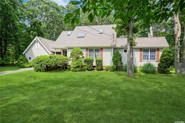 new england style home with a front lawn and a shingled roof
