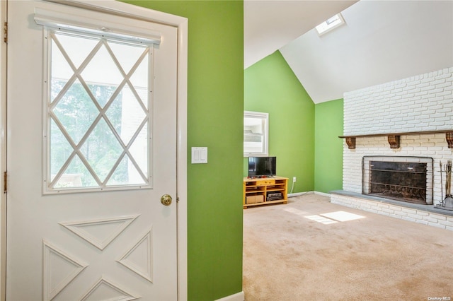 entryway with carpet, lofted ceiling with skylight, and a brick fireplace