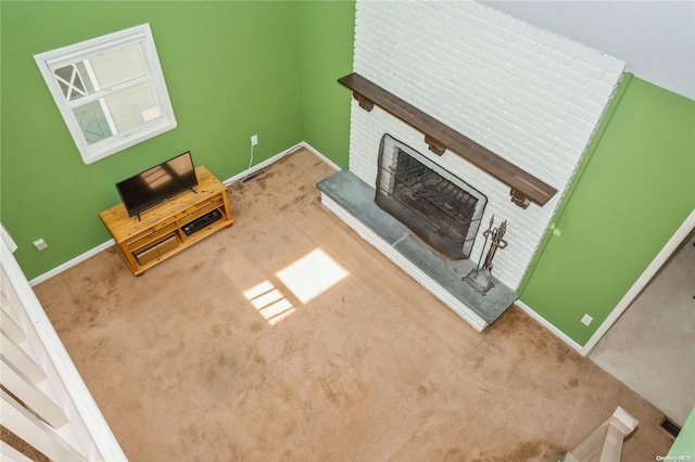 unfurnished living room featuring carpet and a brick fireplace