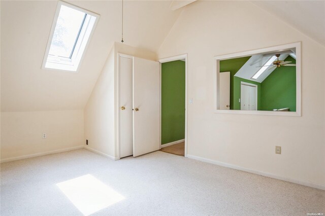 additional living space featuring a skylight, lofted ceiling, carpet, and baseboards