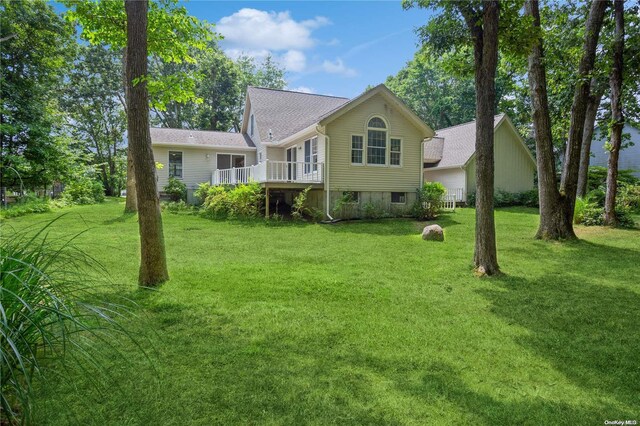 back of house with a lawn and a wooden deck