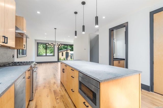 216 N St, Greenport, NY 11944 - kitchen featuring stainless steel appliances, ventilation hood, light wood-style flooring, light brown cabinets, and a center island