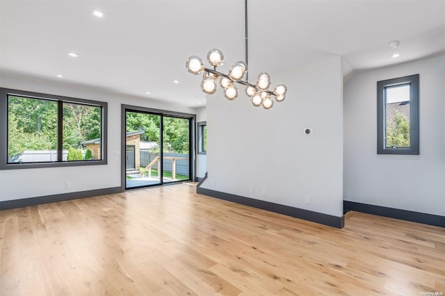 216 N St, Greenport, NY 11944 - spare room with recessed lighting, plenty of natural light, light wood-style flooring, and a chandelier