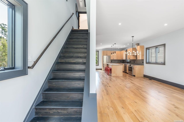216 N St, Greenport, NY 11944 - staircase with a chandelier, plenty of natural light, recessed lighting, and wood finished floors