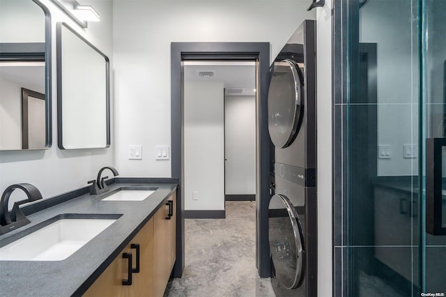 216 N St, Greenport, NY 11944 - bathroom featuring estacked washer and dryer, double vanity, and a stall shower