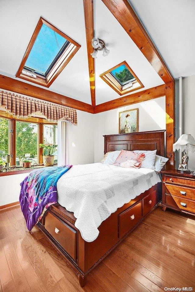 bedroom featuring light wood-type flooring and lofted ceiling with skylight