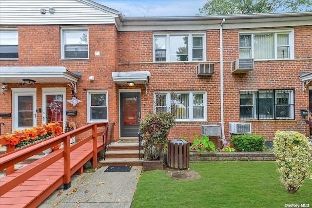 view of property featuring a front lawn and a wooden deck